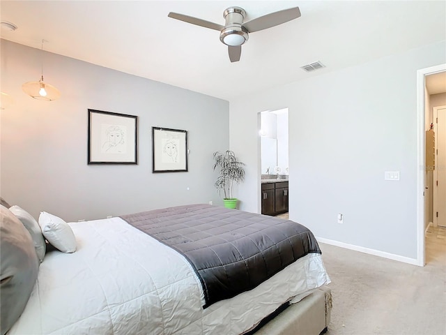 bedroom featuring light carpet, ceiling fan, and ensuite bathroom