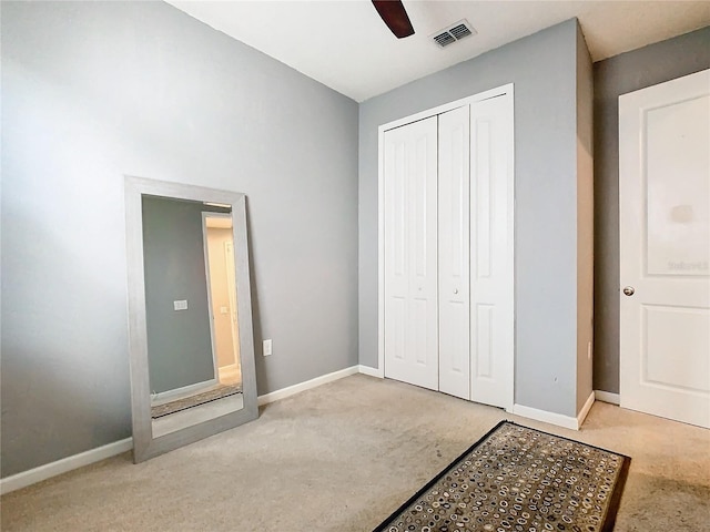 bedroom with a closet, ceiling fan, and light colored carpet