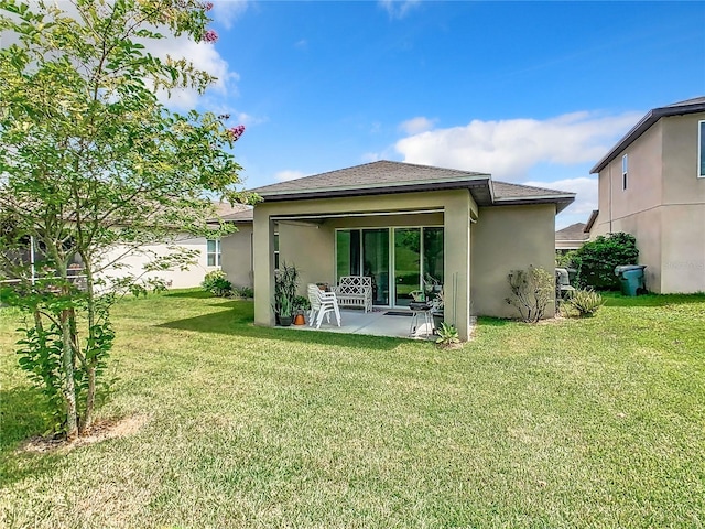 rear view of house with a lawn and a patio