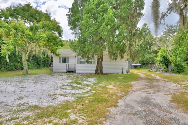 view of front of home with a playground and a front lawn