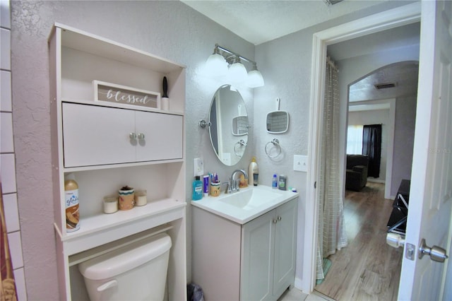 bathroom featuring a textured ceiling, toilet, vanity, and hardwood / wood-style floors