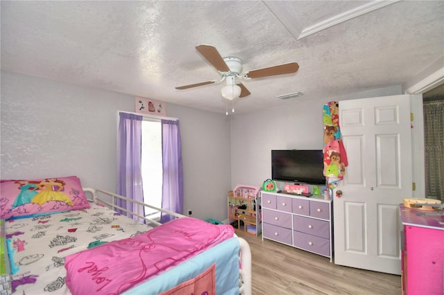 bedroom with ceiling fan, a textured ceiling, and light wood-type flooring