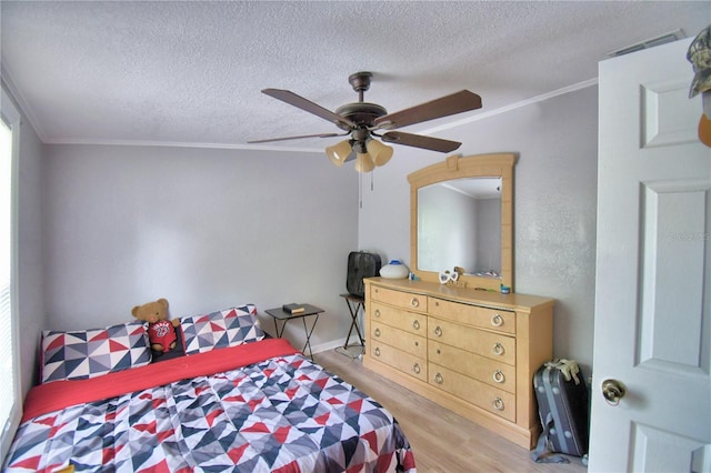 bedroom featuring light wood-type flooring, a textured ceiling, ornamental molding, and ceiling fan