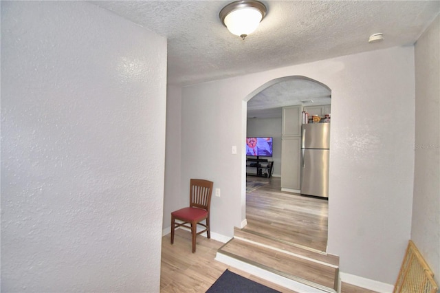 hall featuring a textured ceiling and hardwood / wood-style flooring