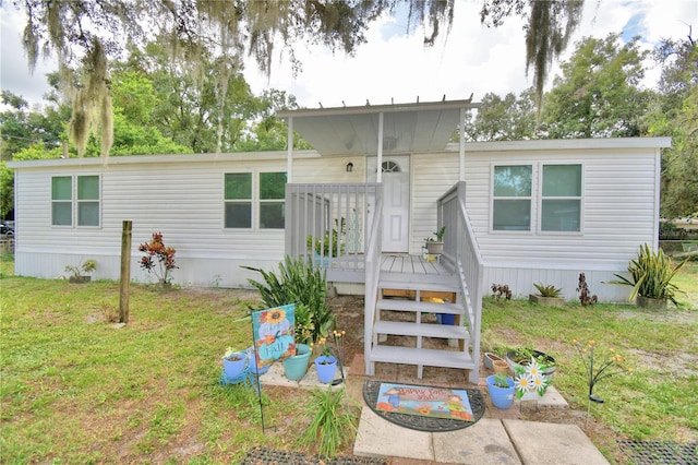 view of front of home featuring a front lawn and a deck