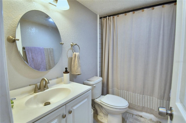 bathroom featuring a textured ceiling, vanity, toilet, and walk in shower