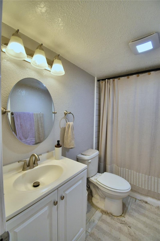 bathroom with wood-type flooring, a textured ceiling, toilet, vanity, and curtained shower