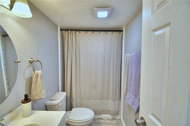 bathroom featuring a textured ceiling, vanity, toilet, and a shower with curtain