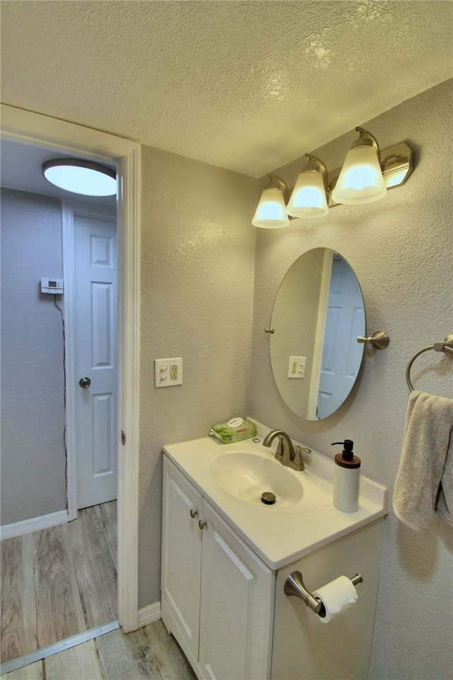 bathroom featuring vanity, hardwood / wood-style flooring, and a textured ceiling