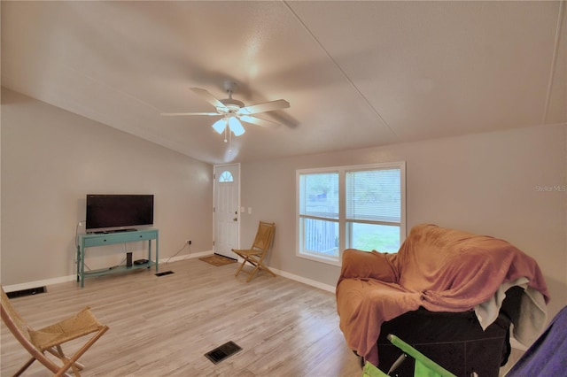 living room featuring light hardwood / wood-style flooring, vaulted ceiling, and ceiling fan