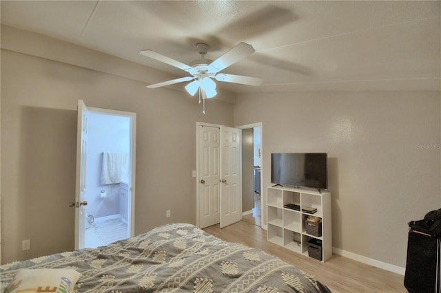 bedroom with light wood-type flooring, a closet, vaulted ceiling, ensuite bath, and ceiling fan