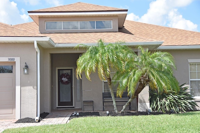 doorway to property with a yard and a garage