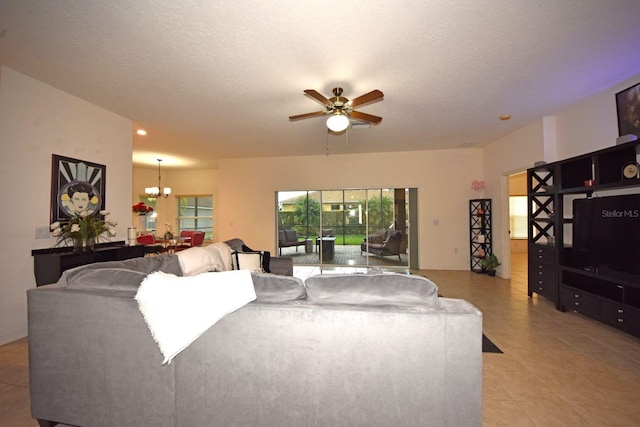 tiled living room featuring a textured ceiling and ceiling fan with notable chandelier