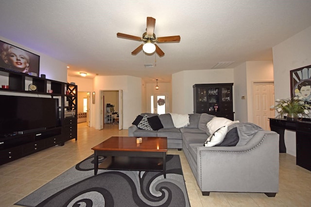 tiled living room featuring a textured ceiling and ceiling fan