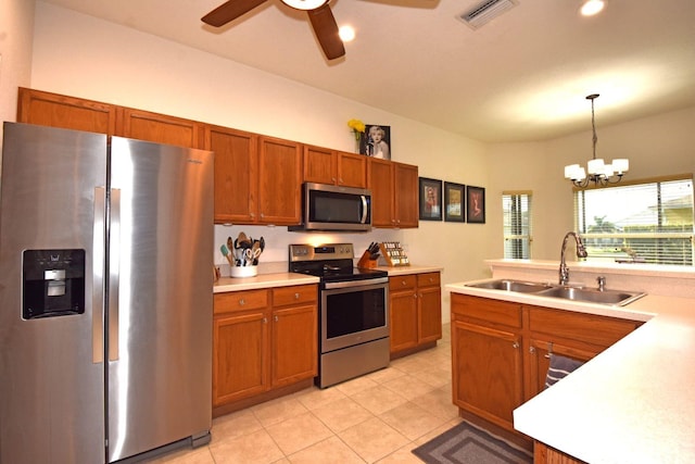 kitchen featuring pendant lighting, light tile patterned floors, sink, appliances with stainless steel finishes, and ceiling fan with notable chandelier