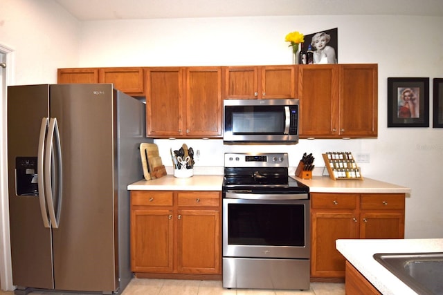 kitchen featuring light tile patterned flooring and stainless steel appliances