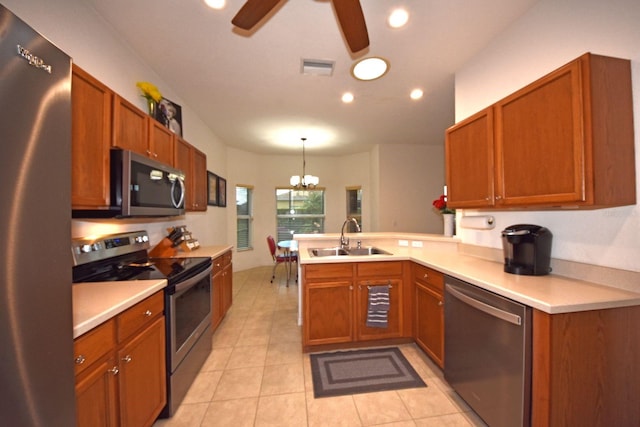 kitchen featuring sink, kitchen peninsula, hanging light fixtures, stainless steel appliances, and light tile patterned floors