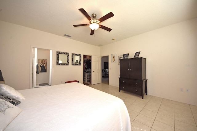 bedroom featuring light tile patterned floors, ceiling fan, a walk in closet, and a closet