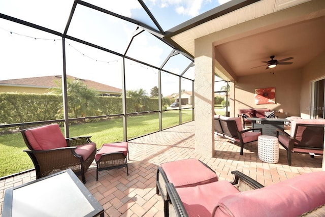 view of patio featuring ceiling fan, an outdoor hangout area, and glass enclosure