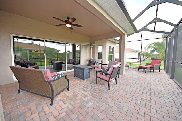 view of patio featuring an outdoor hangout area, glass enclosure, and ceiling fan