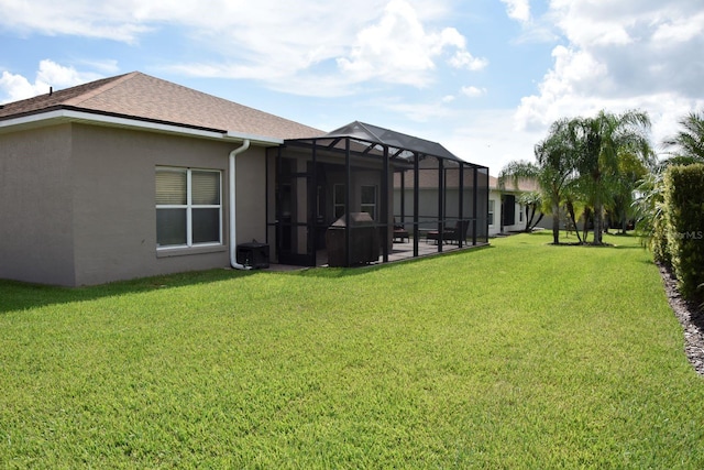 view of yard featuring a patio, glass enclosure, and central AC