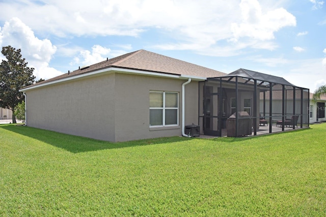 rear view of house featuring a yard and a lanai