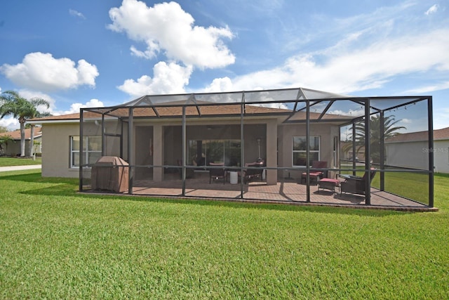 back of property with glass enclosure, a patio area, and a lawn