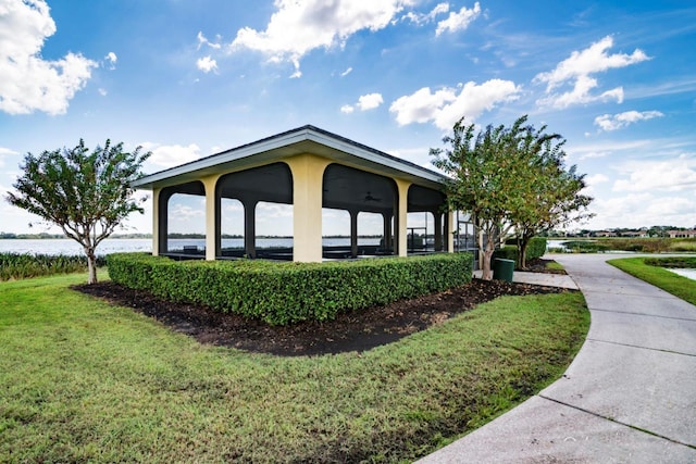 view of property exterior with a gazebo, a yard, and a water view