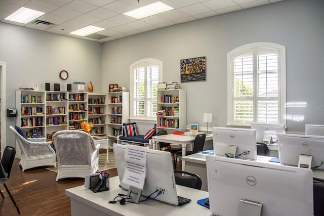 office space featuring hardwood / wood-style flooring, a drop ceiling, and a wealth of natural light