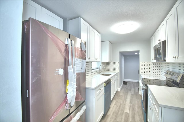 kitchen featuring black appliances, white cabinetry, sink, and tasteful backsplash