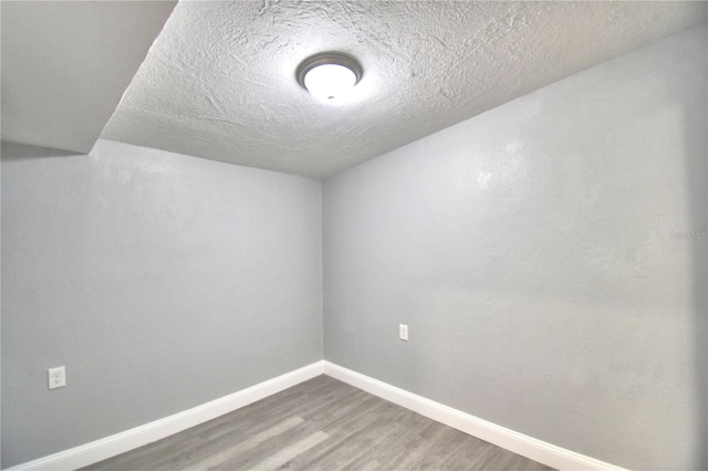 empty room featuring a textured ceiling and hardwood / wood-style floors