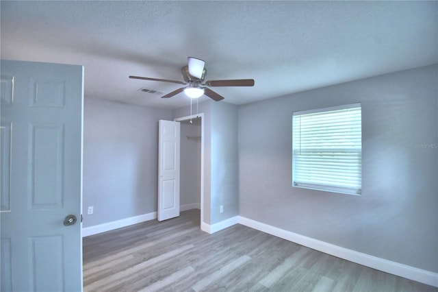 empty room featuring ceiling fan, hardwood / wood-style flooring, and a textured ceiling