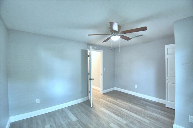 empty room with ceiling fan and hardwood / wood-style floors