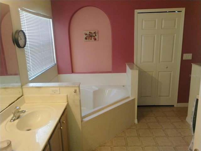 bathroom featuring vanity and a relaxing tiled tub