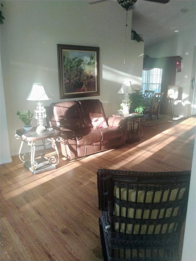 unfurnished living room featuring ceiling fan, vaulted ceiling, and wood finished floors