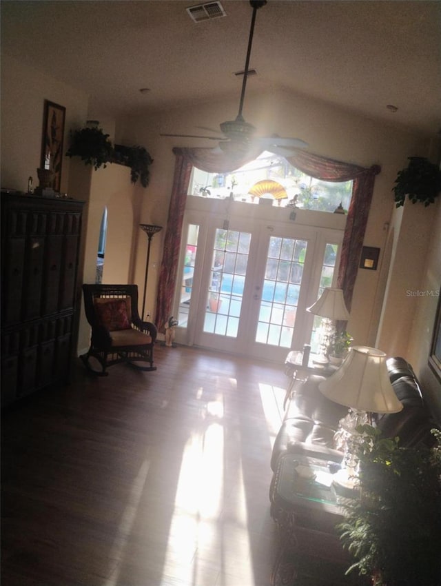 interior space with vaulted ceiling, wood finished floors, visible vents, and a ceiling fan