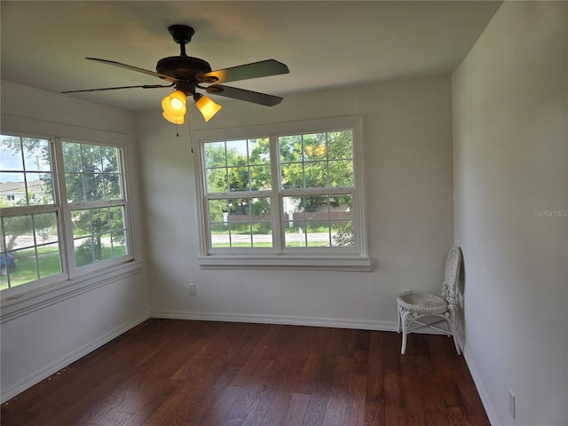 spare room featuring dark wood-type flooring and ceiling fan