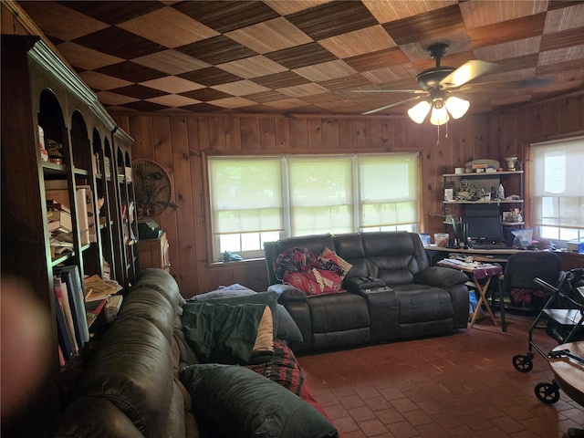 living room with wooden ceiling, wood walls, ceiling fan, and plenty of natural light