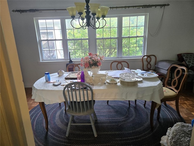 dining space featuring parquet flooring and a notable chandelier