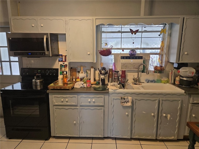 kitchen with white cabinets, plenty of natural light, sink, and electric range