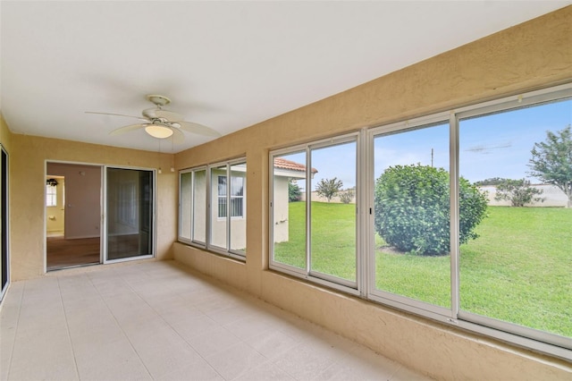 unfurnished sunroom with ceiling fan