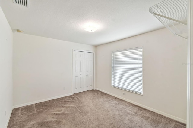 unfurnished room with a textured ceiling and carpet