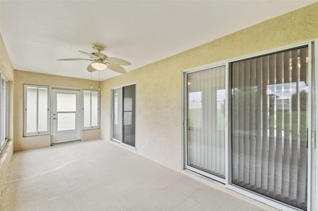 unfurnished sunroom with ceiling fan