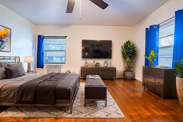 bedroom with ceiling fan, dark hardwood / wood-style floors, and radiator