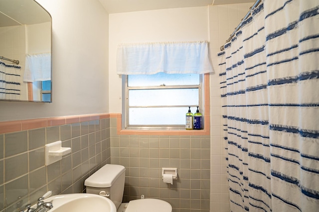 bathroom with tile walls, sink, toilet, and walk in shower