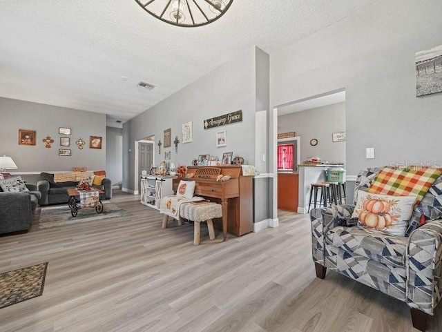 living room featuring a textured ceiling and light hardwood / wood-style floors