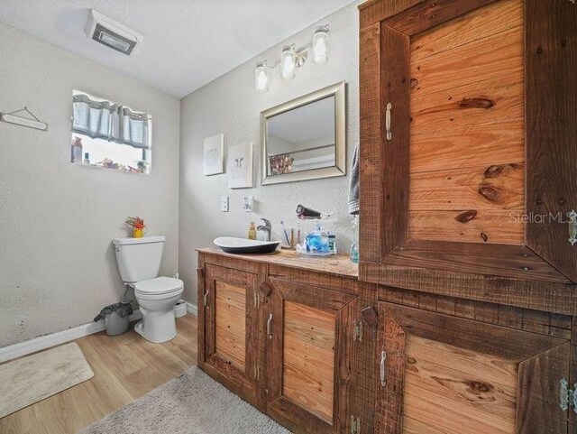 bathroom featuring vanity, toilet, and hardwood / wood-style floors