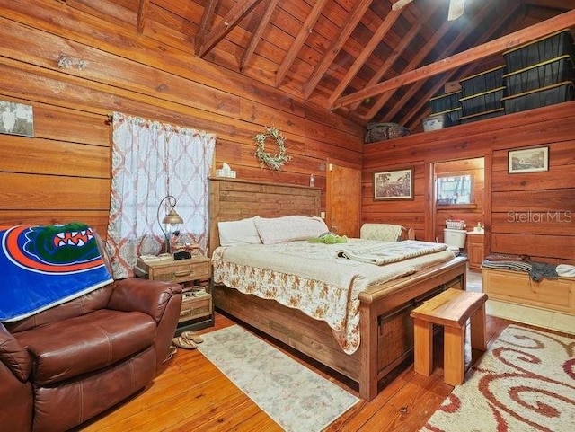 bedroom featuring wood ceiling, high vaulted ceiling, wood walls, beamed ceiling, and light hardwood / wood-style flooring