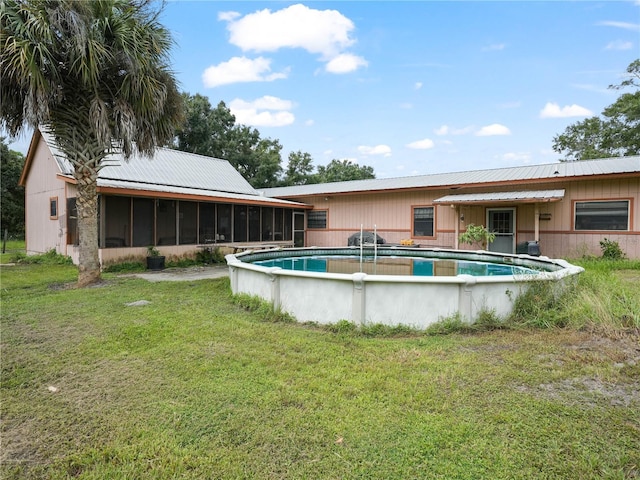 view of pool with a sunroom and a yard