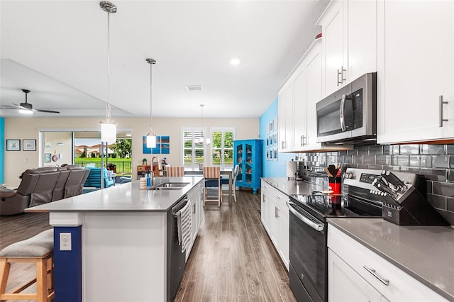 kitchen with ceiling fan, white cabinets, a kitchen island with sink, and stainless steel appliances